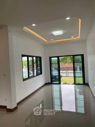Spacious modern living room with large windows and recessed lighting