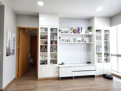 Modern living room with sleek white cabinetry and decorative shelving