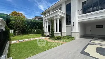 Luxurious modern home with spacious driveway and manicured garden, perfect for upscale living.