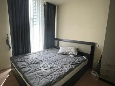 Cozy bedroom with modern decor and large window for natural light.