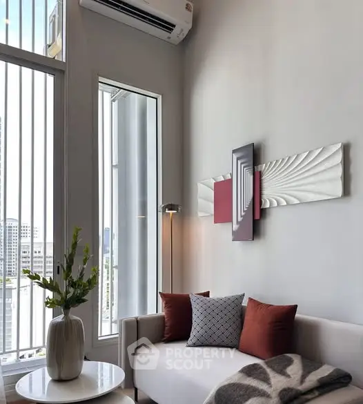 Modern living room with high ceilings, stylish decor, and large windows offering city views.