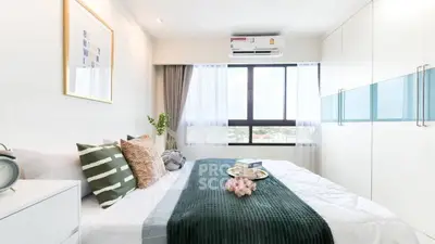Bright and modern bedroom with large window and stylish decor in a high-rise apartment.