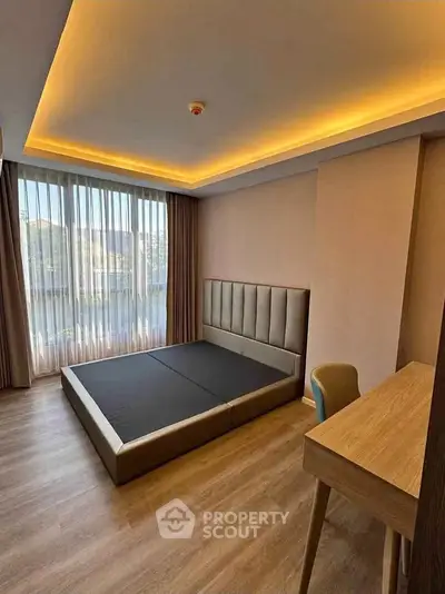 Modern bedroom with stylish lighting and large window in a contemporary apartment.