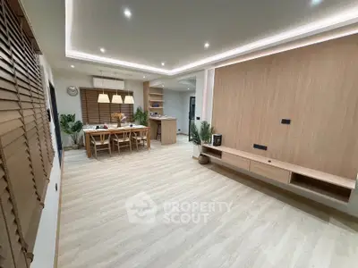 Spacious modern living room with elegant dining area and stylish wooden flooring.