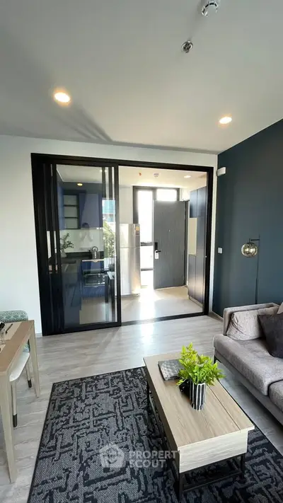 Modern living room with stylish decor and open layout leading to kitchen area.