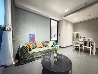 Modern living room with stylish decor and dining area, featuring cozy sofa and elegant table setting.