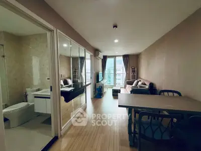 Modern apartment interior with open living room and adjacent bathroom, featuring sleek design and natural light.