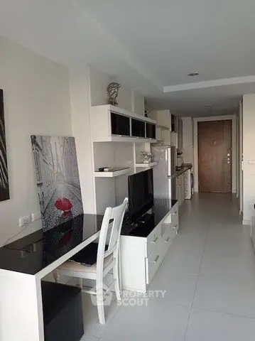 Modern apartment interior with sleek furniture and open layout, featuring a stylish desk and entertainment area.