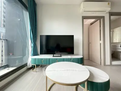 Modern living room with stylish furniture and large window view in a high-rise apartment.
