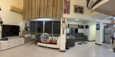 Spacious living room with modern decor and large windows offering city views.