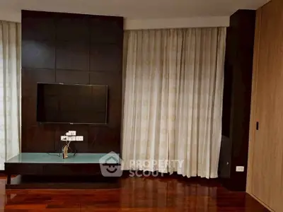 Modern living room with sleek TV setup and elegant curtains