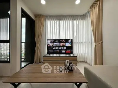 Modern living room with large windows and stylish furniture in a high-rise apartment.