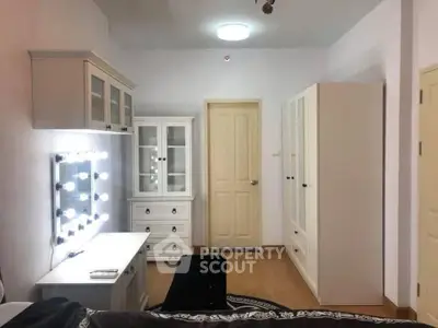 Spacious bedroom with elegant white furniture and vanity mirror lighting