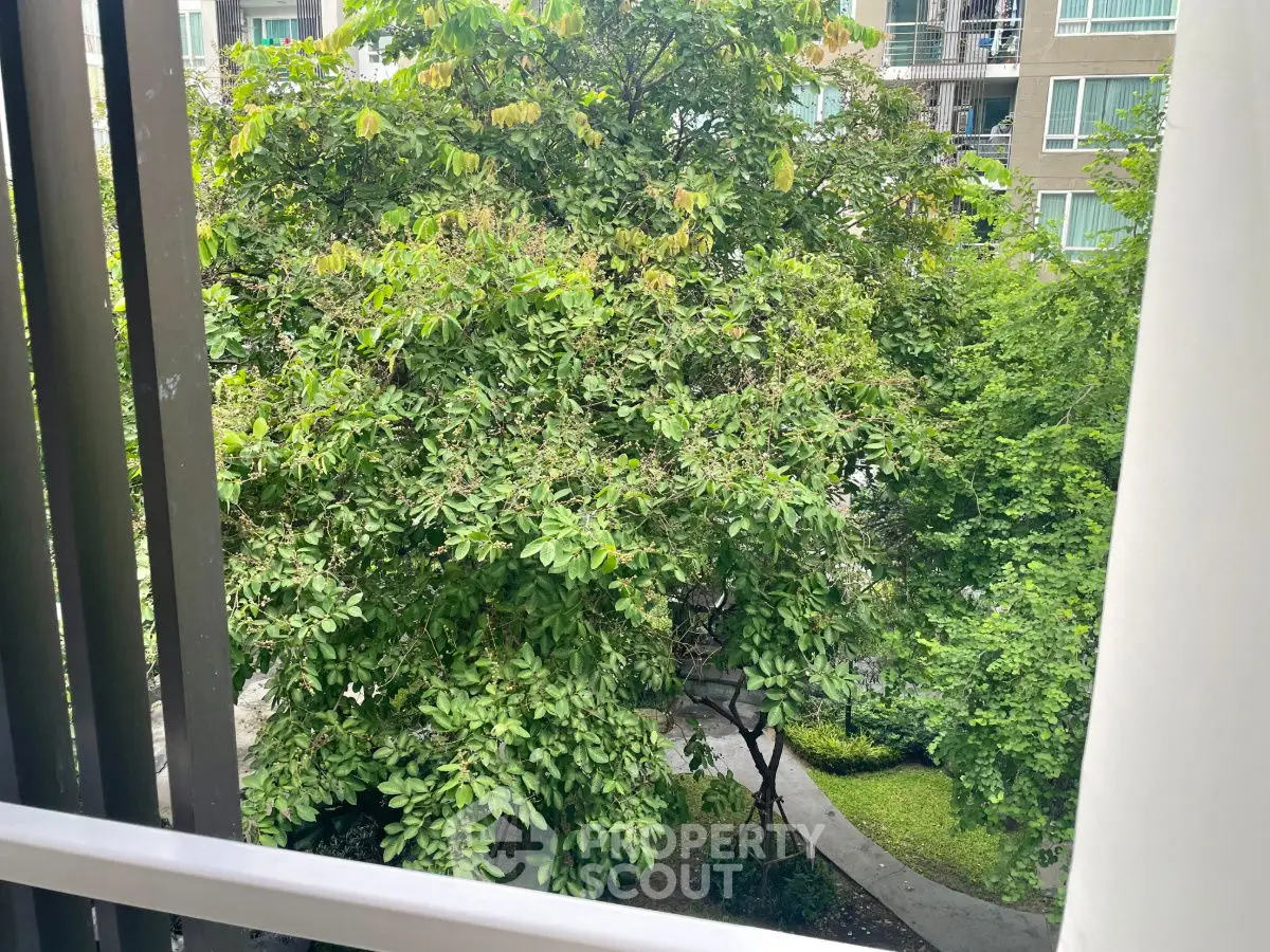 Lush garden view from balcony in modern apartment complex