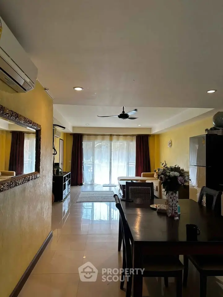 Spacious living room with dining area, modern decor, and large windows for natural light.
