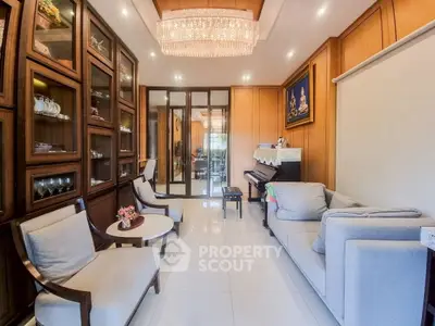 Elegant living room with chandelier, glass cabinets, and cozy seating area.