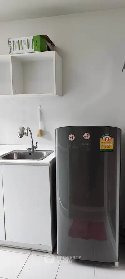 Modern kitchen with sleek fridge and minimalist design, perfect for contemporary living.