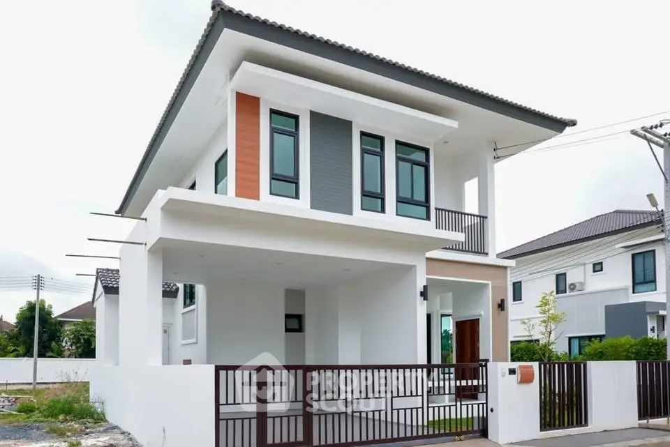 Modern two-story house with sleek design and spacious balcony in a suburban neighborhood.