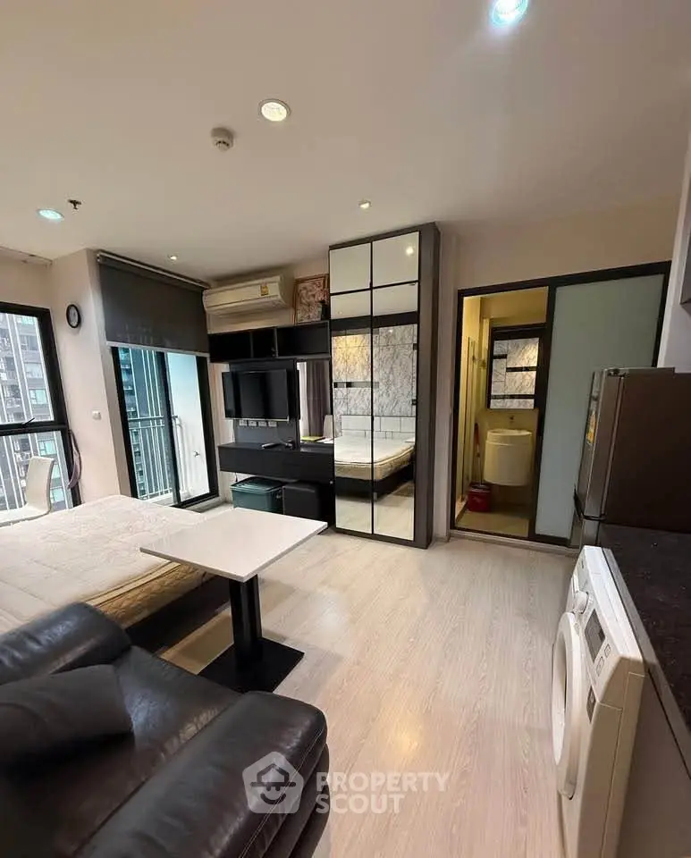 Modern studio apartment with sleek design and integrated appliances in urban setting.