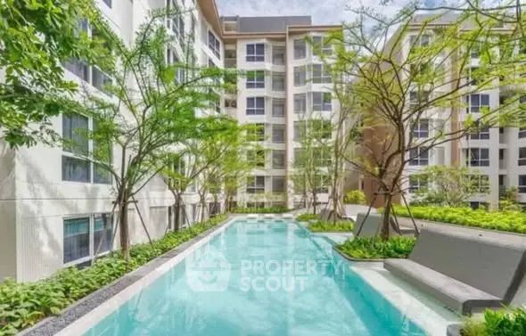 Luxurious apartment complex with serene pool and lush greenery, perfect for modern living.