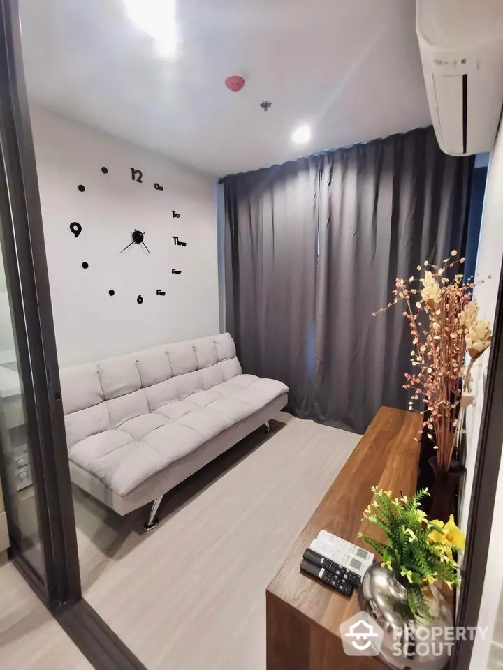 Modern living room with stylish sofa and wall clock, perfect for cozy relaxation.