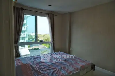 Cozy bedroom with large window offering scenic view in modern apartment