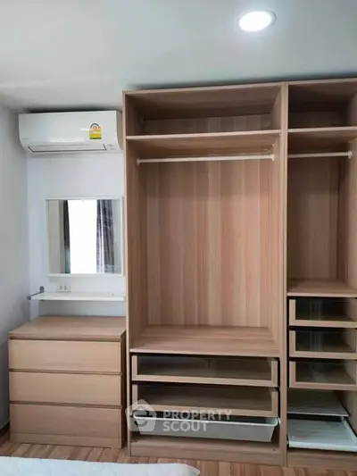 Spacious bedroom with built-in wooden wardrobe and air conditioning unit.