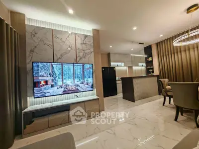 Luxurious open-concept living room with modern marble accents and sleek kitchen design.