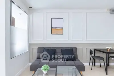 Modern living room with stylish sofa, glass coffee table, and elegant wall art.