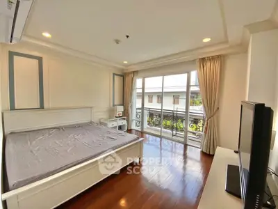 Spacious bedroom with balcony access and elegant decor in a modern apartment.