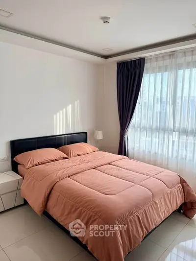 Cozy bedroom with modern decor and large window for natural light