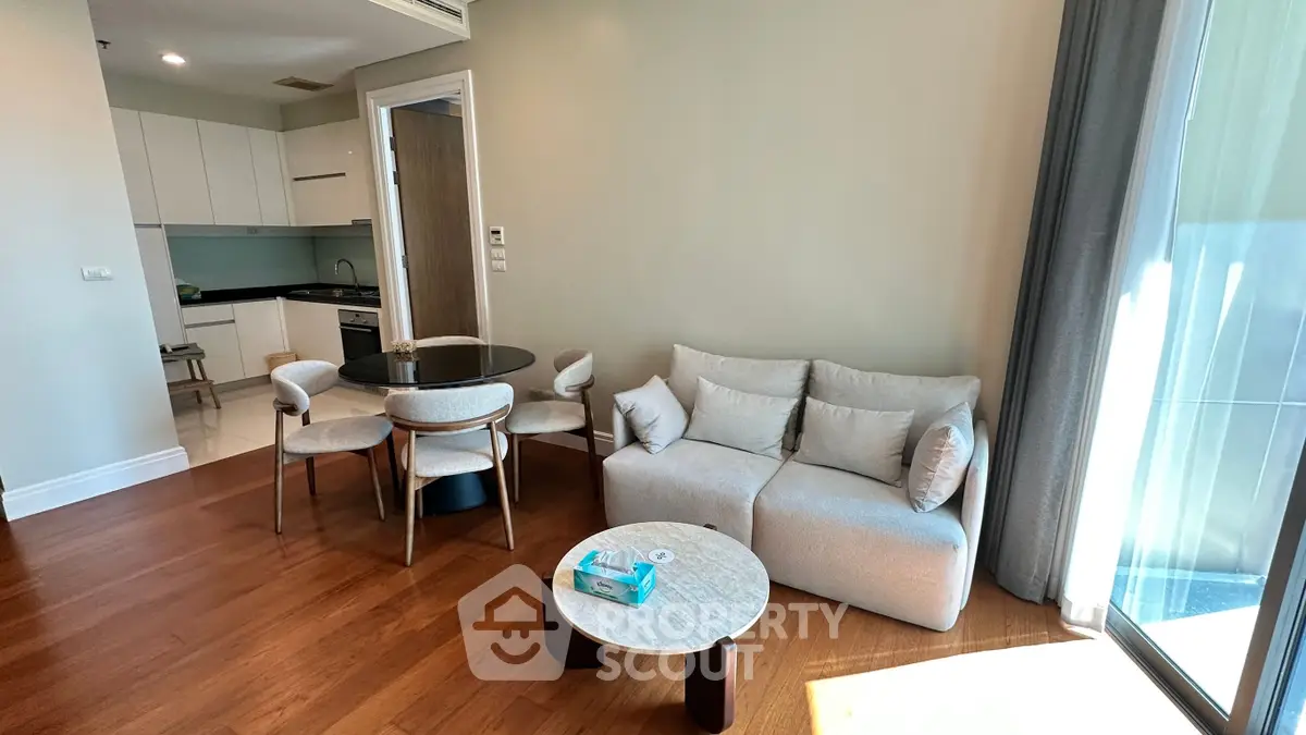 Modern living room with cozy sofa, dining set, and open kitchen layout in bright apartment.