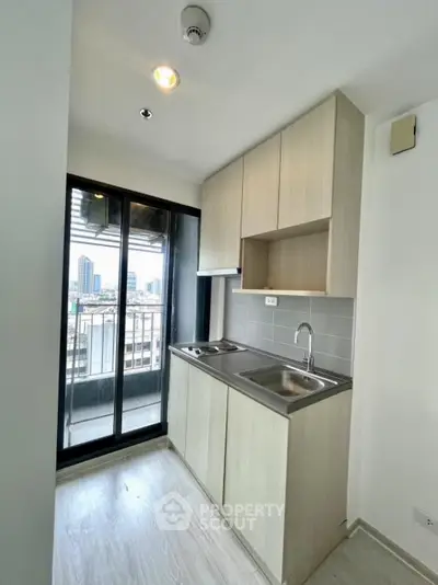 Modern compact kitchen with city view and sleek cabinetry
