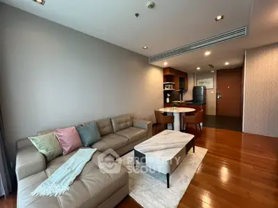 Modern living room with cozy sectional sofa and elegant dining area in open layout apartment.