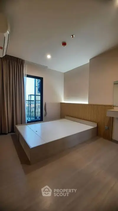 Modern minimalist bedroom with platform bed and balcony access