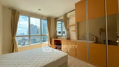 Spacious bedroom with city view, large windows, and built-in wardrobe in modern apartment.