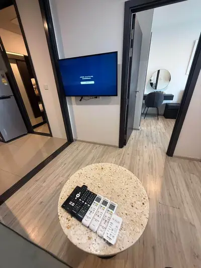 Modern living room with wall-mounted TV and stylish decor in a contemporary apartment.