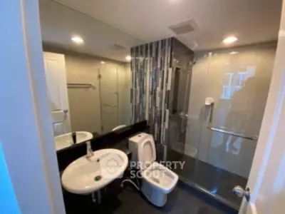 Modern bathroom with glass shower and sleek fixtures in a contemporary apartment.