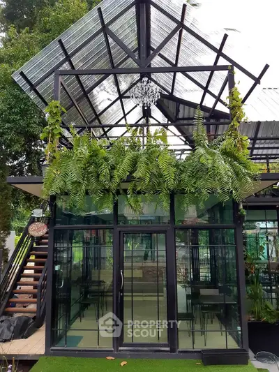 Modern glass greenhouse with lush greenery and stylish architecture