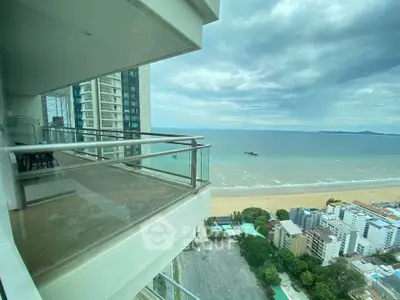 Stunning beachfront balcony with panoramic ocean views in a luxury high-rise apartment.