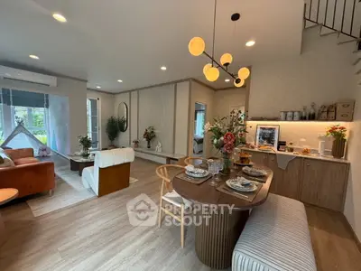 Spacious open-plan living and dining area with modern decor and elegant lighting.