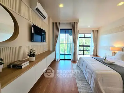 Spacious modern bedroom with large window and stylish decor