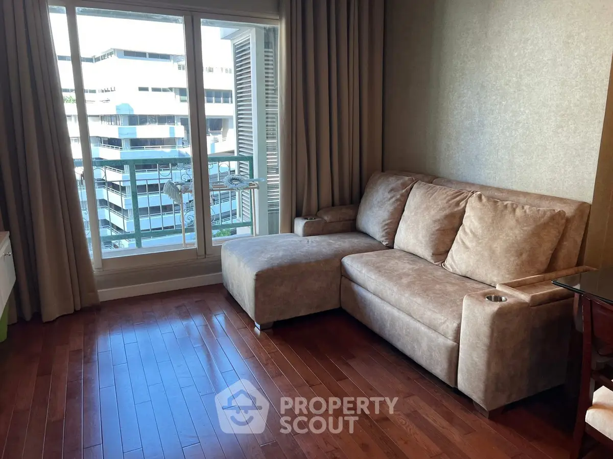 Spacious living room with modern sofa and large window offering city view