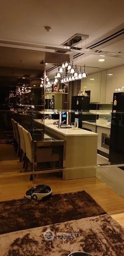 Luxurious modern kitchen with sleek design and elegant lighting, featuring a stylish island and high-end appliances.