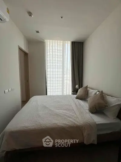 Modern bedroom with natural light and minimalist decor in a stylish apartment.