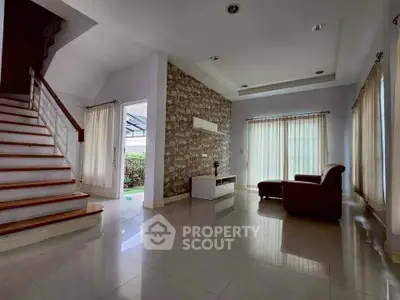 Spacious living room with modern staircase and natural light