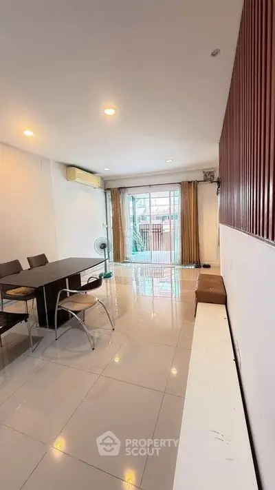 Spacious living room with modern dining area and large window for natural light.