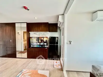 Modern living room with sleek wooden cabinetry and wall-mounted TV