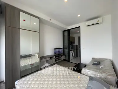 Modern studio apartment with mirrored wardrobe and compact kitchen