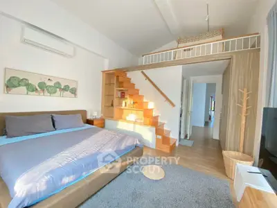 Modern bedroom with loft, cozy decor, and ample natural light